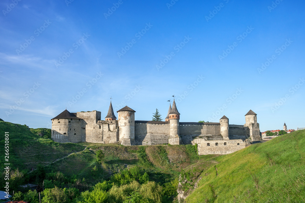 Summer landscape with green fields, antique fortress Kamianets-Podilskyi in Ukraine