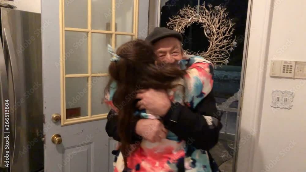 Granddaughter hugging granddad at door in winter Granddaughter hugging granddad at door in winter