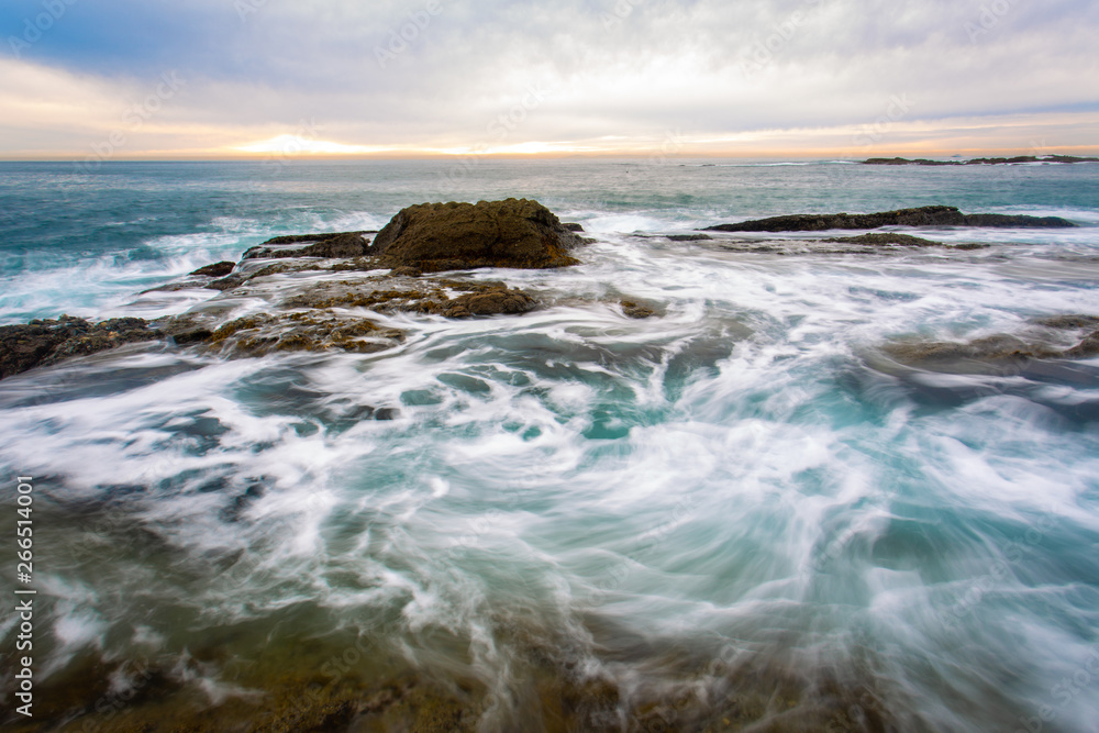 Southern California beach landscape of ocean waves hitting rocks long exposure Southern California beach landscape of ocean waves hitting rocks long exposure