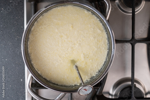 Milk being heated in a pan to make cheese © Andras