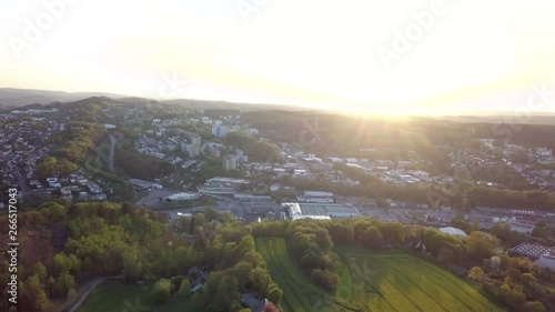 Beautiful city with dense forest areas in its outskirts, seen from a drone flight