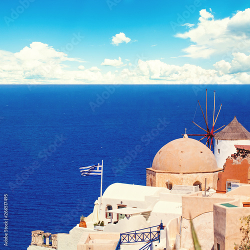 Santorini landscape with greek flag, white houses, sea and blue sky