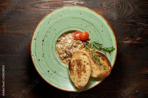 Beef stroganoff with croutons. Dark wooden background. Restaurant menu photo