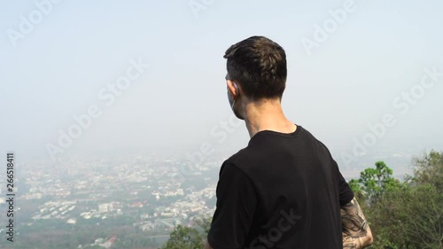 Chiang Mai young man wearing a face mask and looking at the city. photo