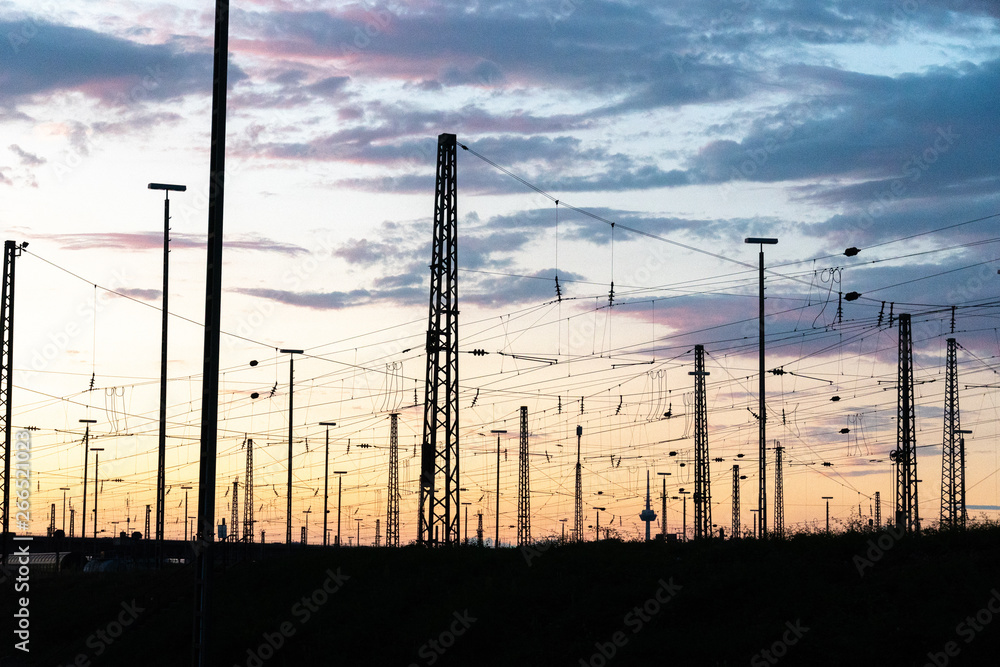 Utility poles and electricity high voltage tower at sunset
