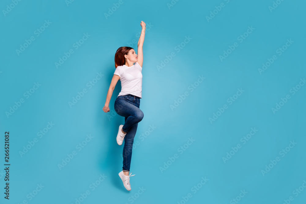 Full length body size profile side view portrait of nice attractive cheerful strong girl in white tshirt active mood life lifestyle raising hand arm up isolated on bright vivid shine blue background