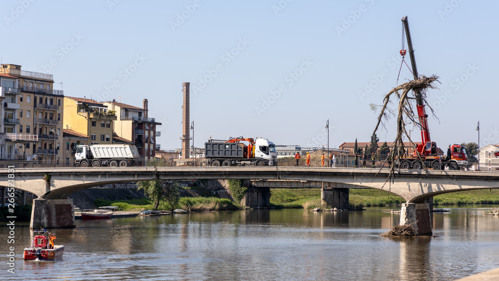 PISA, TUSCANY/ITALY - APRIL 18 : Workmen lifting a dead tree from the Arno river at PisaTuscany Italy on April 18, 2019. Unidentified people PISA, TUSCANY/ITALY - APRIL 18 : Workmen lifting a dead tree from the Arno river at PisaTuscany Italy on April 18, 2019. Unidentified people