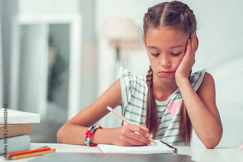 Close-up portrait of bored cute Afro-American girl doing writing homework. Close-up portrait of bored cute Afro-American girl doing writing homework.