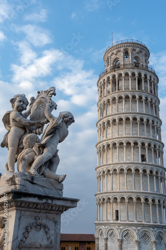 PISA, TUSCANY/ITALY - APRIL 17 : Statue of cherubs in front of the Leaning Tower of Pisa Tuscany Italy on April 17, 2019. Three unidentified people