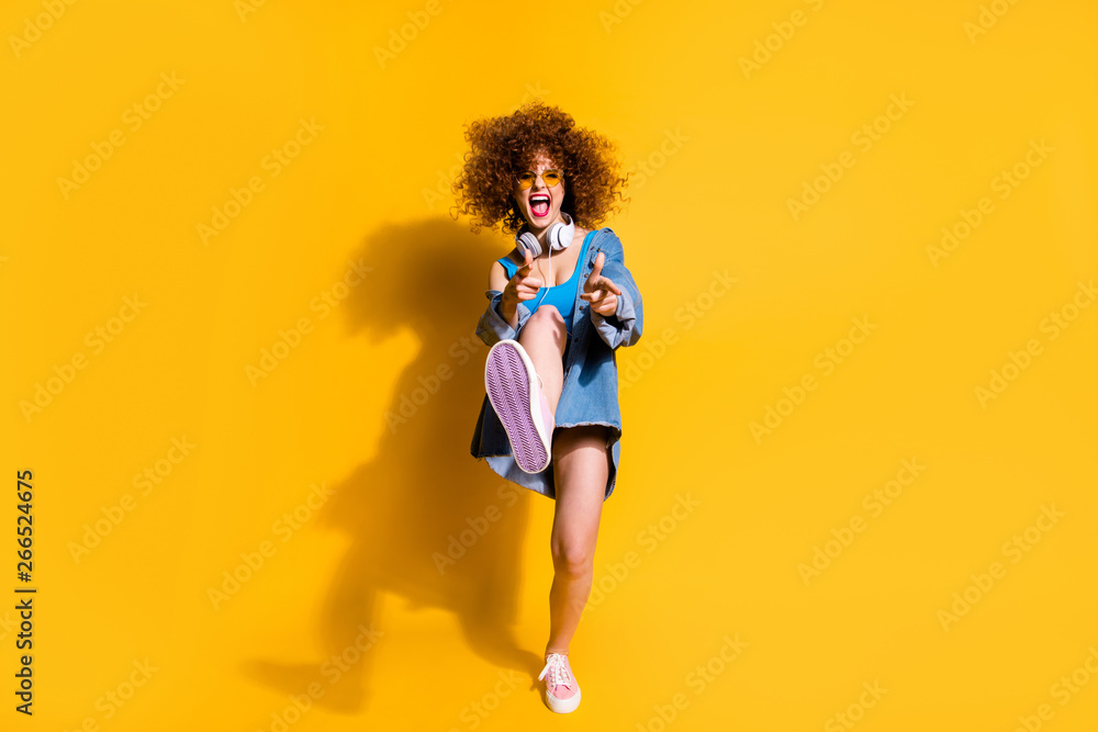 Full length body size photo funky funny she her lady wavy styling clubber strange moves fingers direct wear ear flaps specs casual jeans denim shirt shorts tank top clothes isolated yellow background