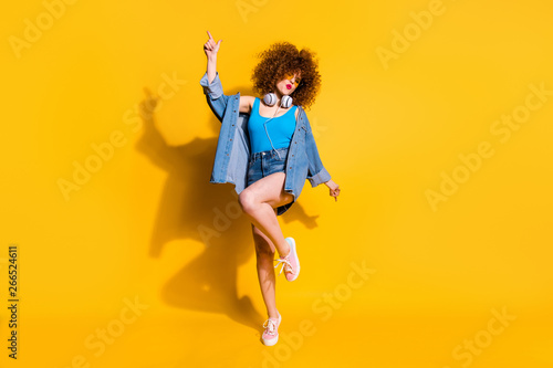 Full length body size photo funny she her lady wavy styling curls clubber sing songs hang out wear headset ear flaps specs casual jeans denim shirt shorts tank top clothes isolated yellow background