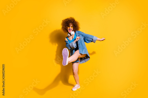 Full length body size photo funny she her lady wavy styling curls clubber strange moves wear headset ear flaps specs casual jeans denim shirt shorts tank top clothes isolated yellow background