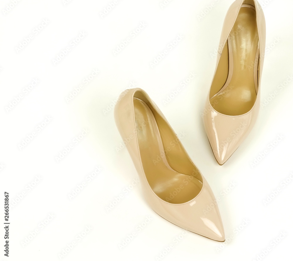 Fototapeta premium women high heel shoes pale pink, beige color on white background. Flat lay, top view trendy beauty female background.Copy space