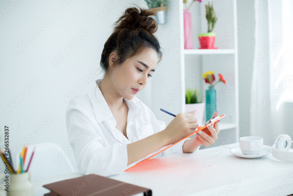 Beautiful young woman working on her laptop in her room. Beautiful young woman working on her laptop in her room.