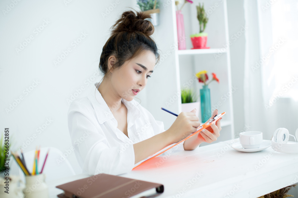 Beautiful young woman working on her laptop in her room.