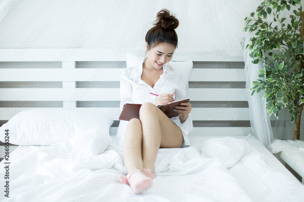 Lifestyle happy young Asian woman enjoying lying on the bed reading book at home. Lifestyle happy young Asian woman enjoying lying on the bed reading book at home.
