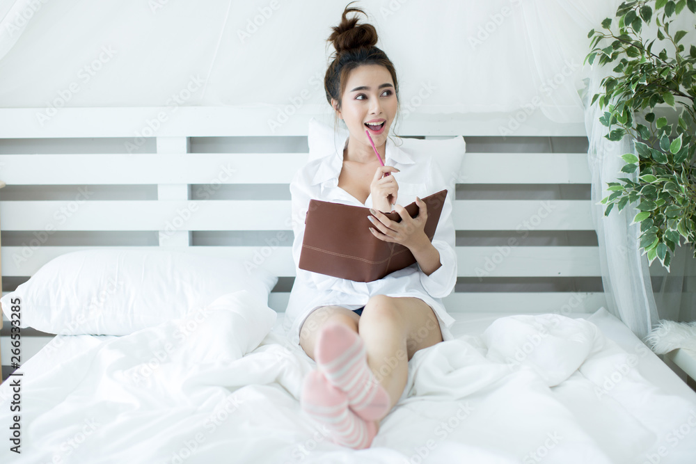 Lifestyle happy young Asian woman enjoying lying on the bed reading book at home. Lifestyle happy young Asian woman enjoying lying on the bed reading book at home.