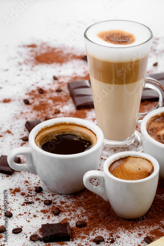 Different types of coffe ,espreso,long coffe ,latte,coffe with milk,on sweet background with coffe beans and chocolate.