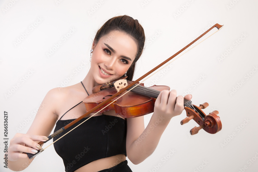 Beautiful young woman playing violin over white background Beautiful young woman playing violin over white background