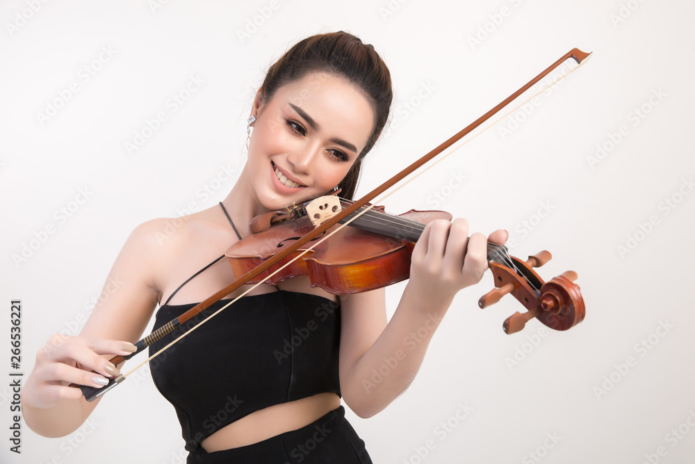 Beautiful young woman playing violin over white background Beautiful young woman playing violin over white background