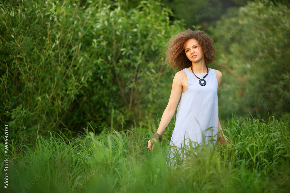 curly girl on the river Bank in the sunset curly girl on the river Bank in the sunset