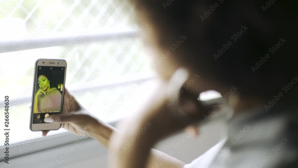 Close-up shot of smiling teenage girl talking selfie while sitting in classroom Close-up shot of smiling teenage girl talking selfie while sitting in classroom