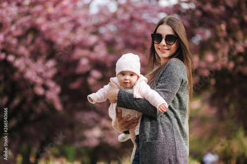 Mom fly with her little baby in tha park. Happy family photo