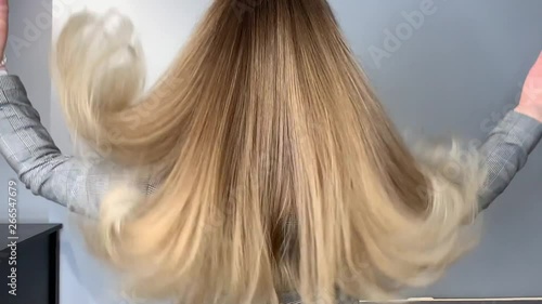 Blonde woman waving her beautiful, healthy hair after a treatment at a beauty salon, before and after. Slow motion