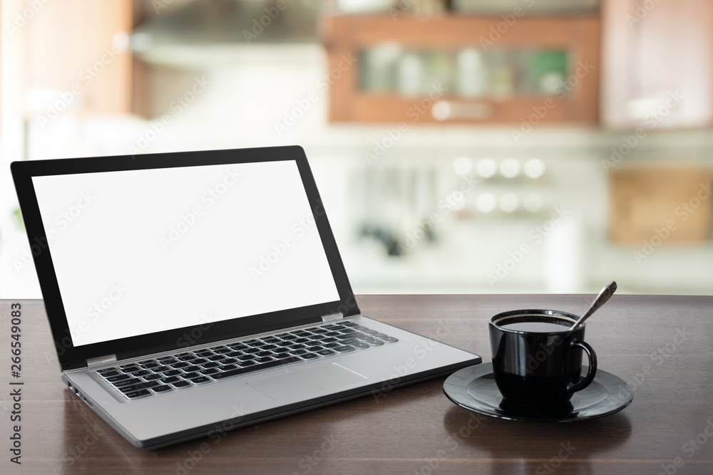 Fototapeta premium Laptop with empty blank screen on wooden tabletop with modern blur kitchen background.