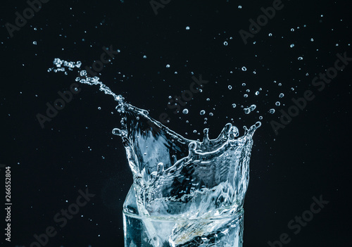 Water splash in glass with black background photo