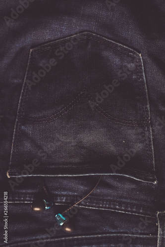 Headphones in the back pocket of jeans. Copy Space Background for advertising