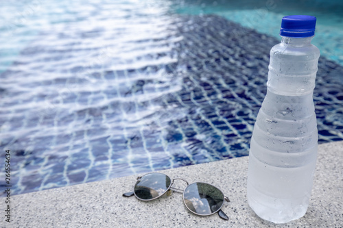plastic bottle and sunglasses on the beach swimming pool