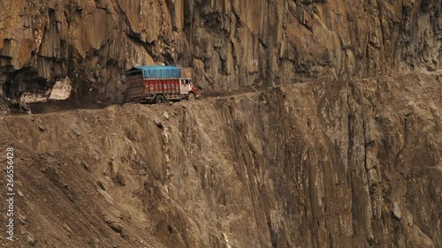 Close-up low-angle still shot of an old truck travelling up a dangerous and narrow mountain pass, Ladakh road. 