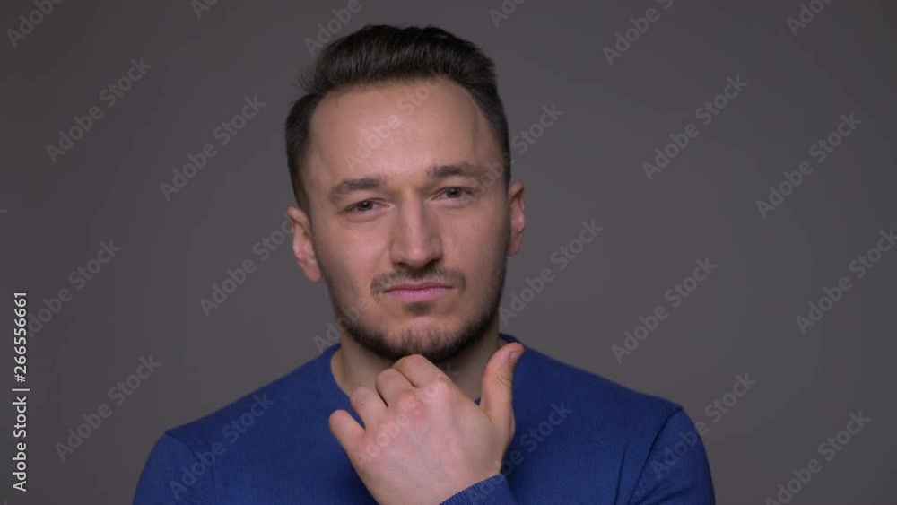 Closeup shoot of young handsome caucasian man waving his head saying no looking at camera with background isolated on gray Closeup shoot of young handsome caucasian man waving his head saying no looking at camera with background isolated on gray