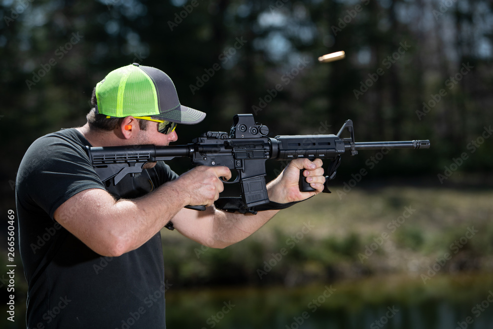 Close-up of man shooting a rifle with the ejected shell.