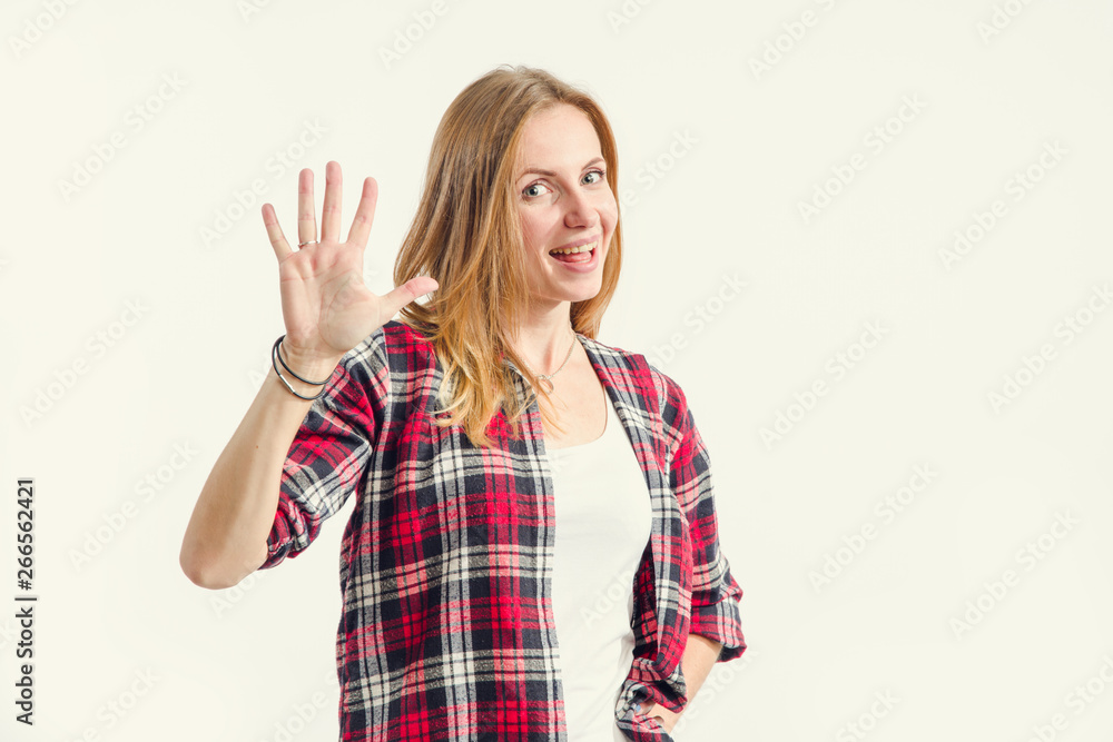 Beautiful young woman shows palm, five fingers standing on a light background. Number 5. Beautiful young woman shows palm, five fingers standing on a light background. Number 5.