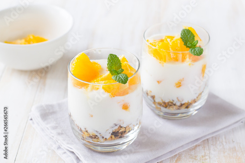 Yogurt, granola and orange in glass es