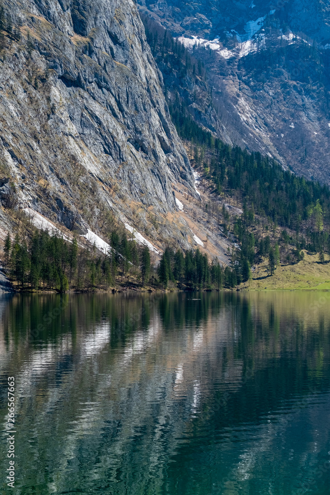 The snowy mountain peaks, trees, houses and lakes at Konigssee, Germany