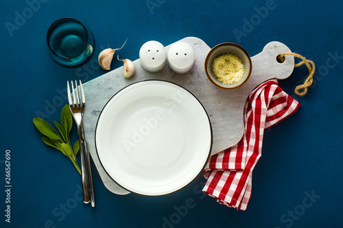 empty served plate on marble serving board and blue spice backgroundi photo