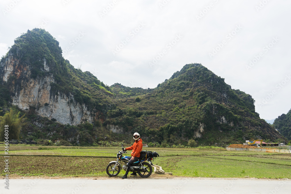 Motorbiker sitting on Motorbike in the North of Vietnam Motorbiker sitting on Motorbike in the North of Vietnam