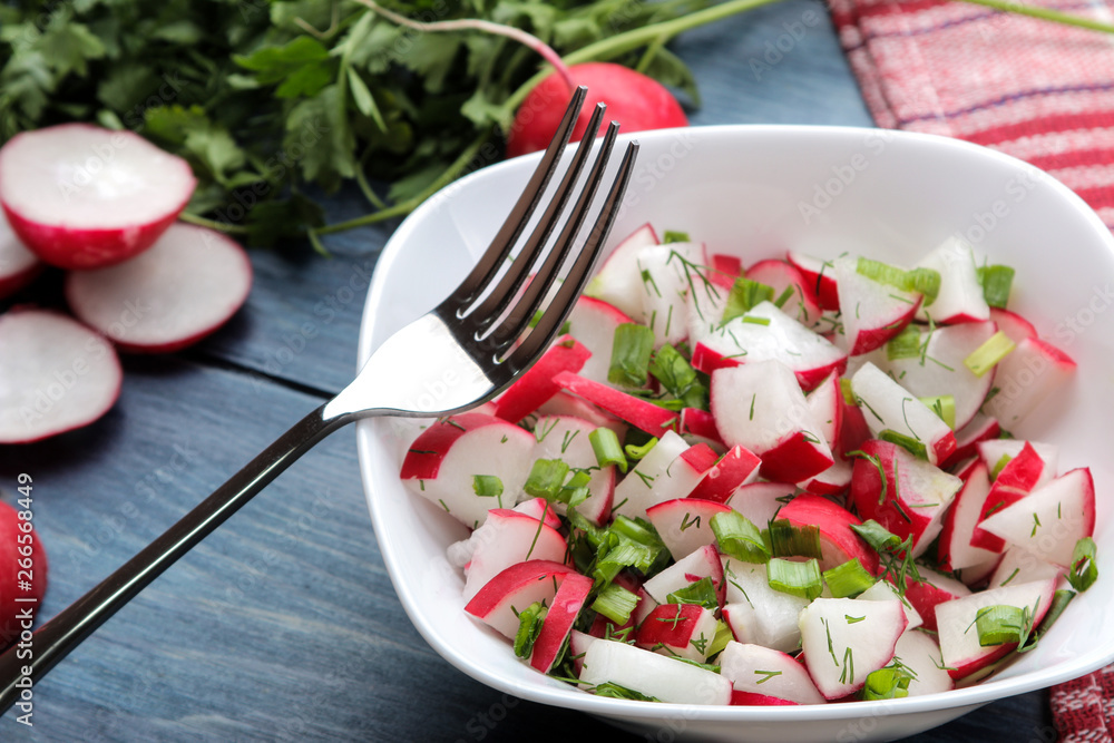 Salad of fresh radishes and fresh herbs on a blue wooden table. Spring vegetable salad. ingredients for cooking salad. Salad of fresh radishes and fresh herbs on a blue wooden table. Spring vegetable salad. ingredients for cooking salad.