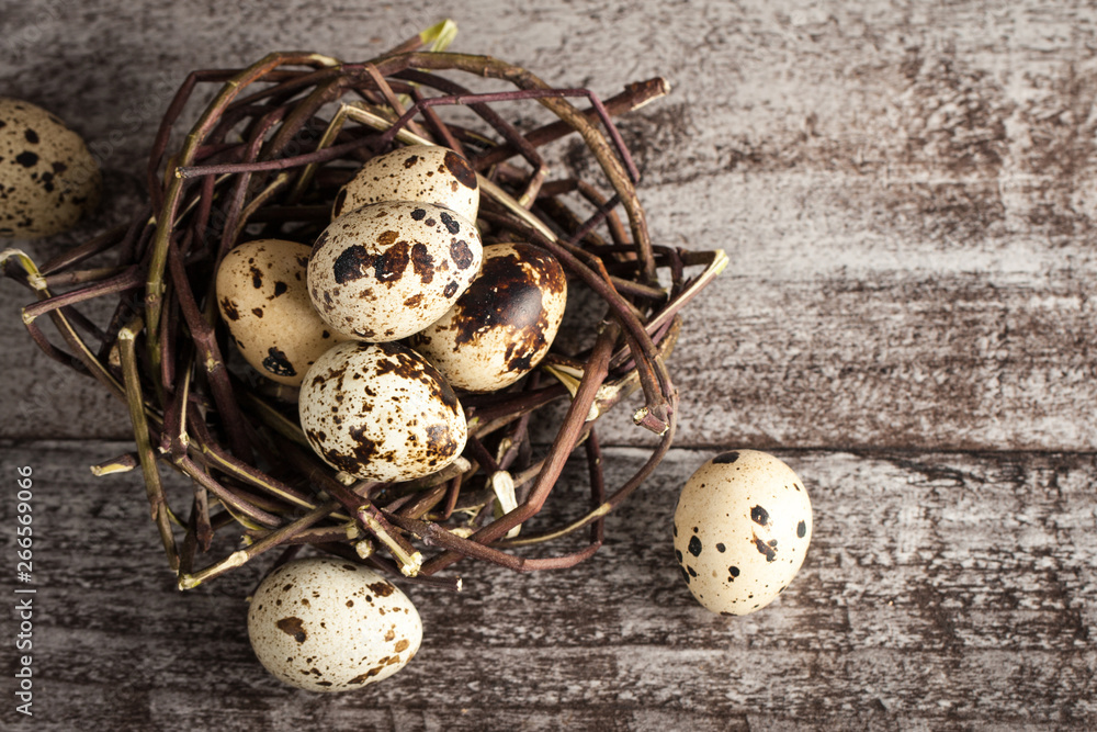 Quail eggs in a nest on a rustic wooden background. Healthy food concept Quail eggs in a nest on a rustic wooden background. Healthy food concept