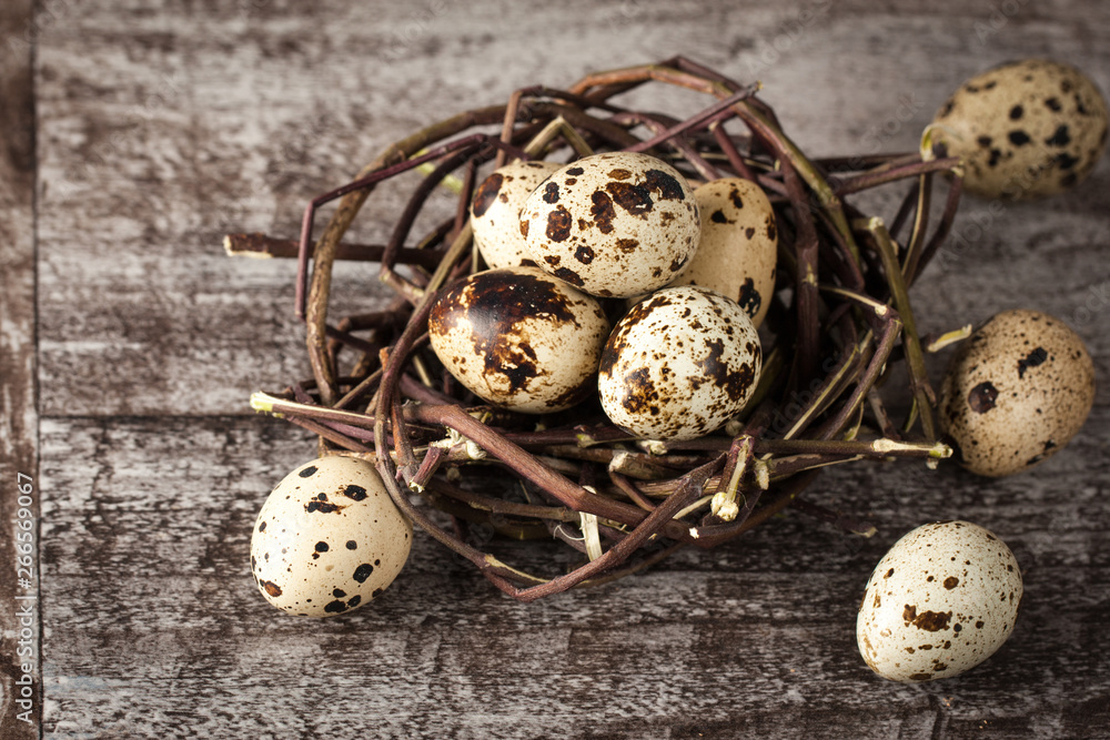 Quail eggs in a nest on a rustic wooden background. Healthy food concept Quail eggs in a nest on a rustic wooden background. Healthy food concept