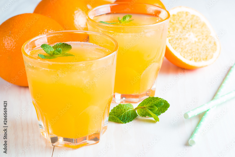 Close-up of a glass of orange juice with oranges fruits on wooden and stone background. Vitamins and minerals. Healthy drink and beverage concept. Close-up of a glass of orange juice with oranges fruits on wooden and stone background. Vitamins and minerals. Healthy drink and beverage concept.