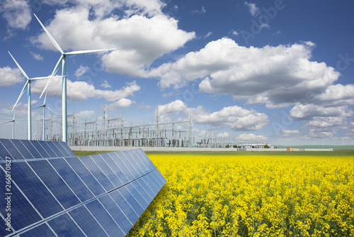 Green energy and transformer substation in a natural environment with blue sky and yellow rape field photo
