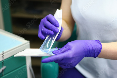 Macro photo of doctor s hands in gloves  which reveals a sterile mirror for dental work. The concept of beauty and health.