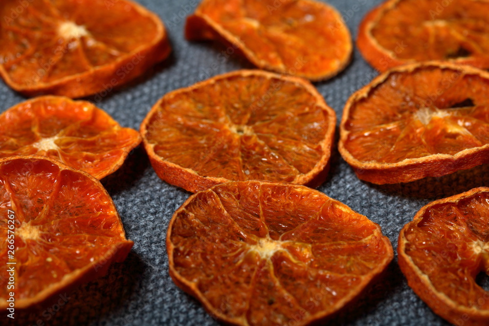 Tangerines are cut into slices and dried to decorate desserts. On a gray background. Tangerines are cut into slices and dried to decorate desserts. On a gray background.