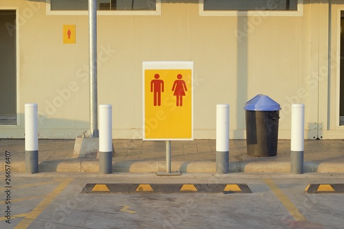 Parking in front of the bathroom in the gas station, signs, women, men Red yellow background.Man and Woman icons. Male and female bathroom signs, simple and modern rounded human figures