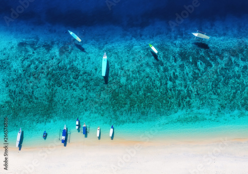 Boat on the water surface from top view. Turquoise water background from top view. Summer seascape from air. Gili Meno island, Indonesia. Travel - image photo