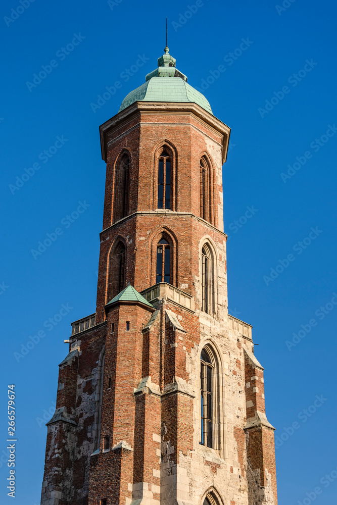 Fototapeta premium Hungary, Budapest, Royal Castle Hill: Tower steeple of famous Saint Mary Magdalene church near Fisherman's Bastion of the Hungarian capital with blue sky in the background - concept travel religion